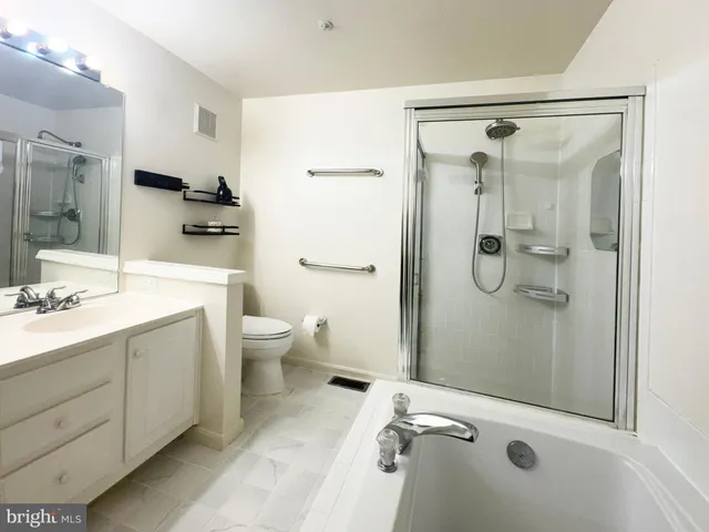 a bathroom with a shower sink mirror and toilet