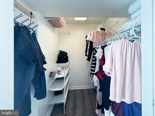 a view of walk in closet with clothes and shoes