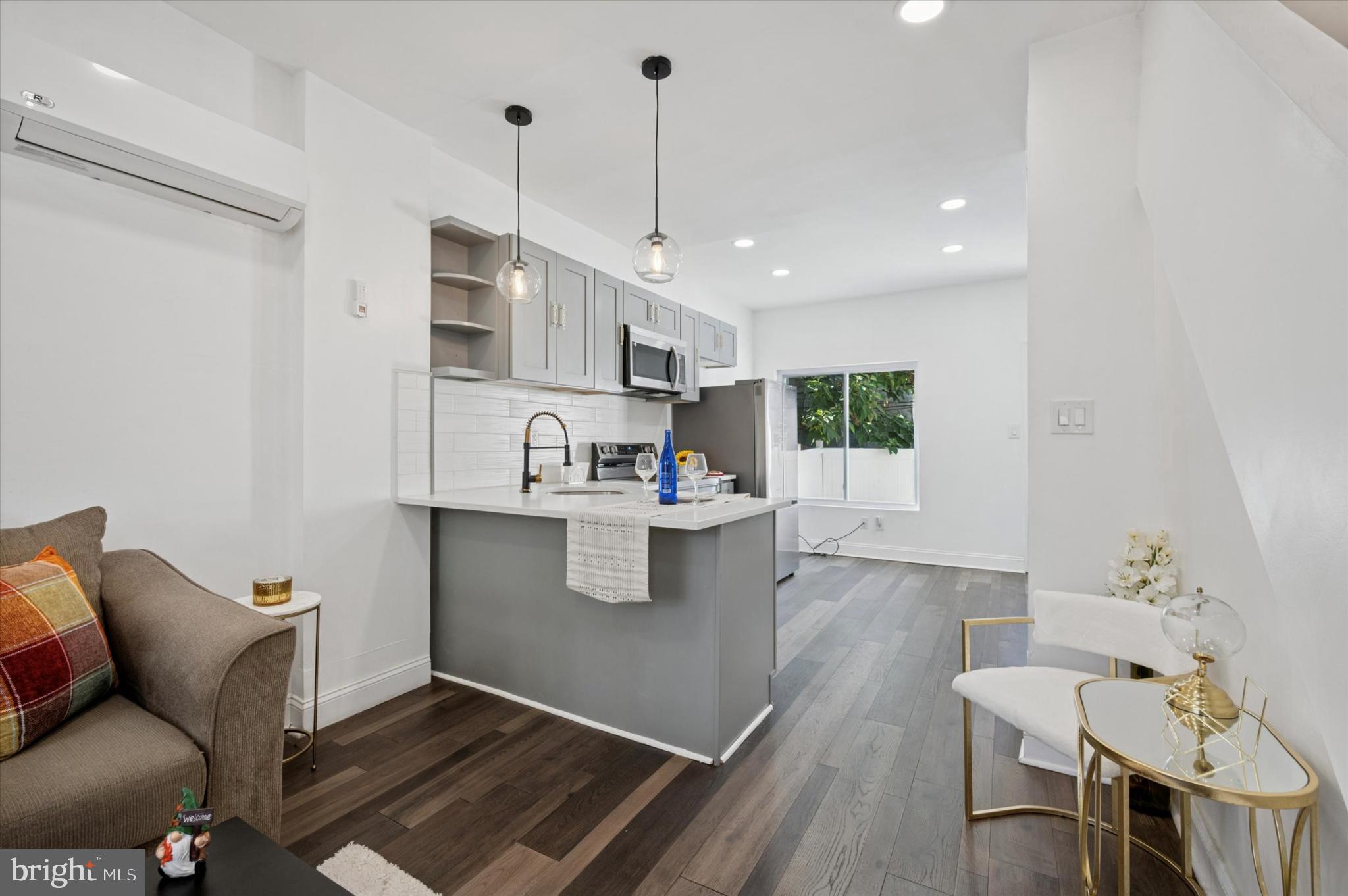 650 East Wensley Street Philadelphia, PA 19134 - Photo 5 of 24 a kitchen with stainless steel appliances kitchen island granite countertop a stove a sink and a refrigerator with wooden floor