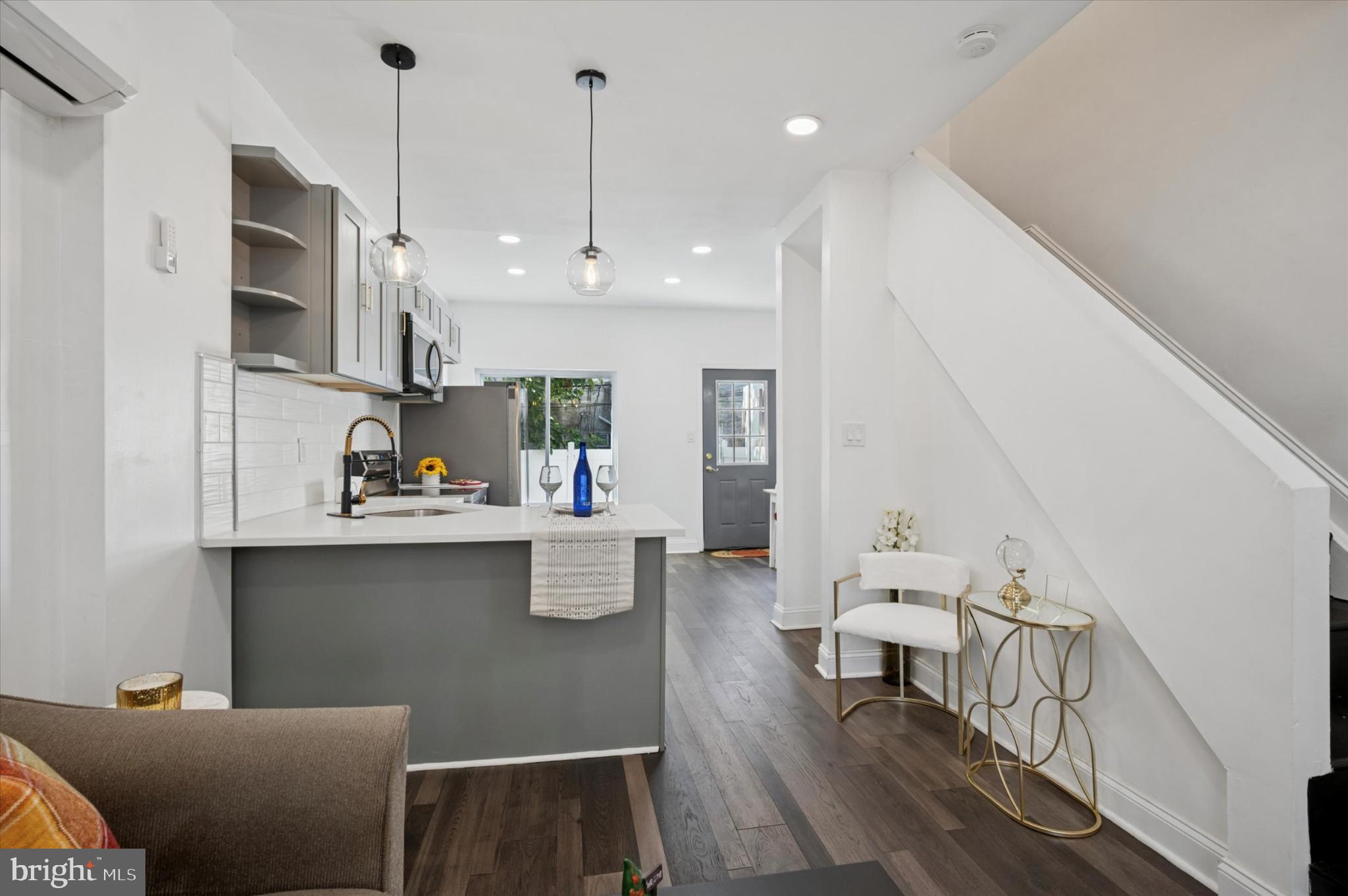 650 East Wensley Street Philadelphia, PA 19134 - Photo 6 of 24 a open kitchen with stainless steel appliances granite countertop a stove top oven a sink a dining table and chairs with wooden floor