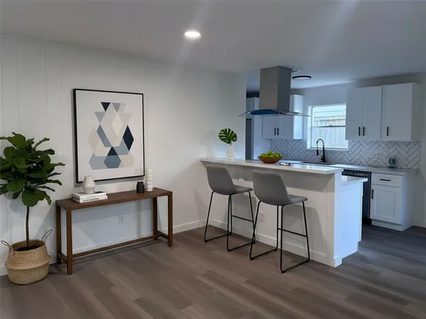a kitchen with granite countertop a sink a counter space and a living room view