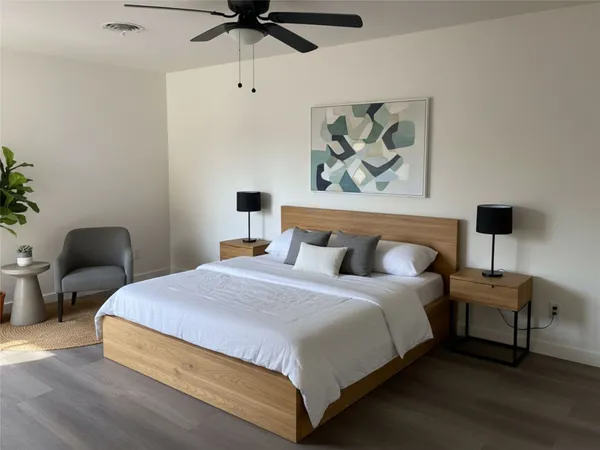 a bedroom with bed and a painting on the wall
