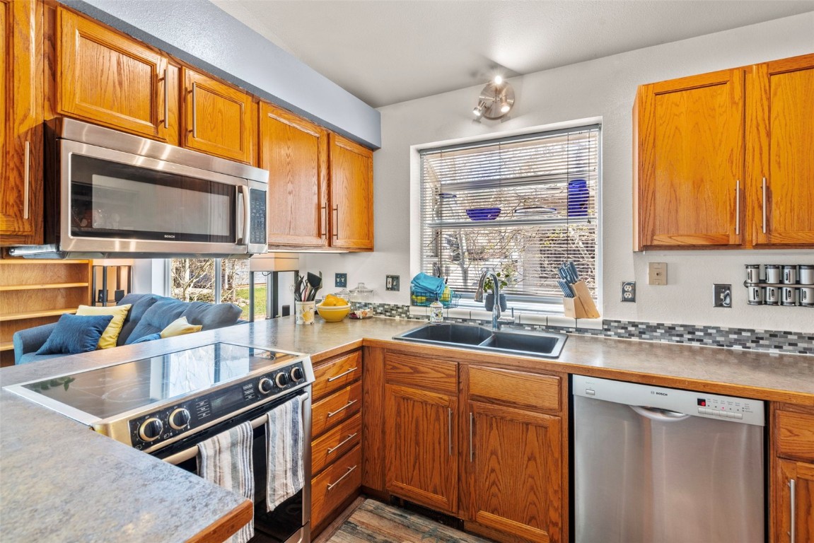 654 Alpine Road Dillon, CO 80435 - Photo 21 of 40 a kitchen with stainless steel appliances granite countertop a stove a sink and a microwave