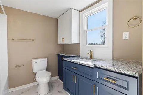 a bathroom with a granite countertop sink a toilet and bathtub