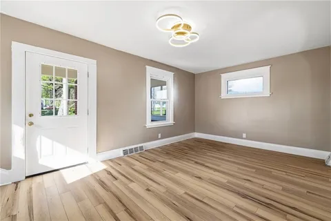 a view of empty room with wooden floor and window