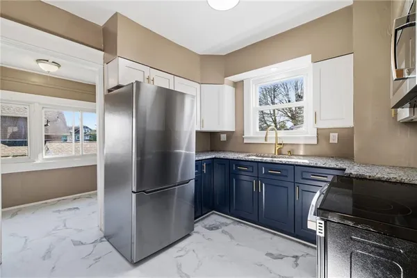 a kitchen with stainless steel appliances granite countertop a refrigerator and a sink