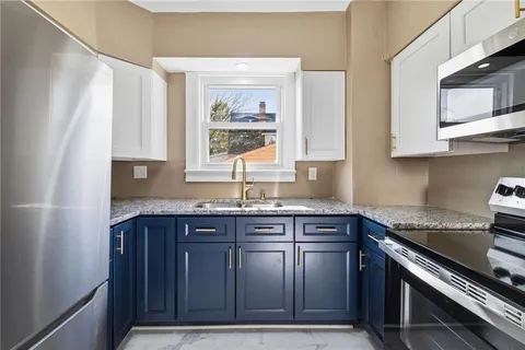 a kitchen with granite countertop a sink stove and cabinets