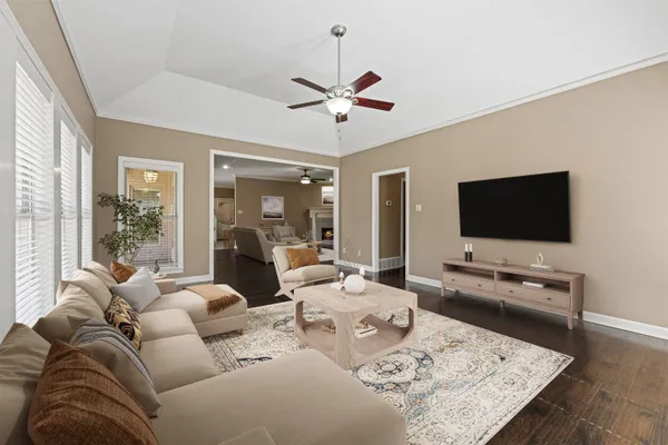 a living room with furniture a flat screen tv and a chandelier