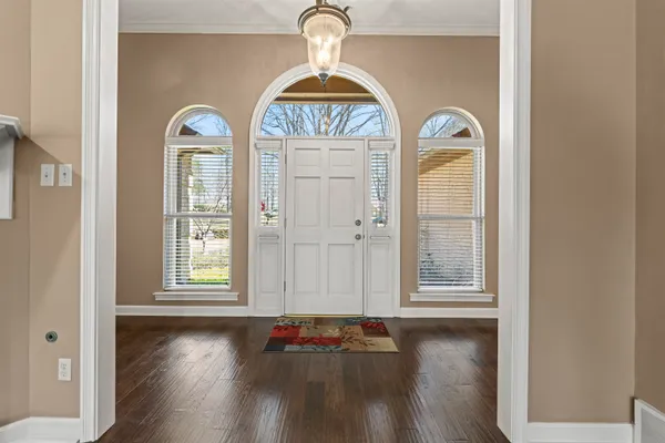 an empty room with wooden floor windows and cabinet
