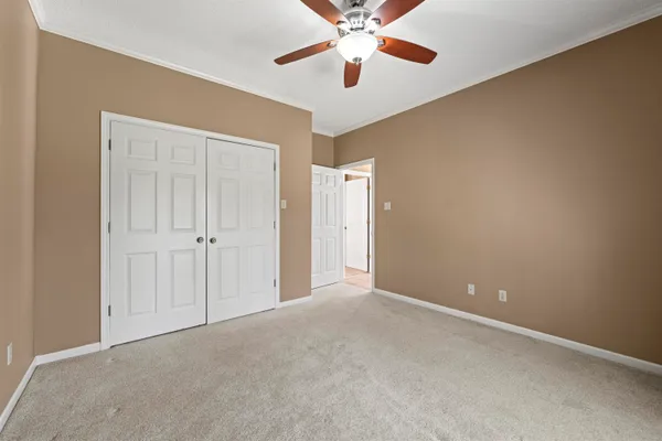 a view of an empty room and chandelier fan