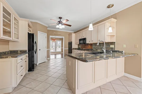 a kitchen with stainless steel appliances granite countertop a stove cabinets and chandelier