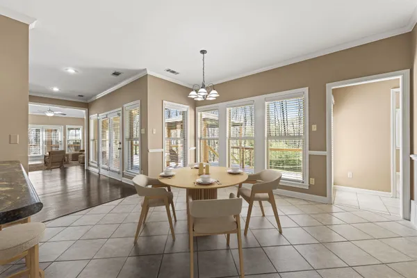 a dining room with chandelier fan and wooden floor