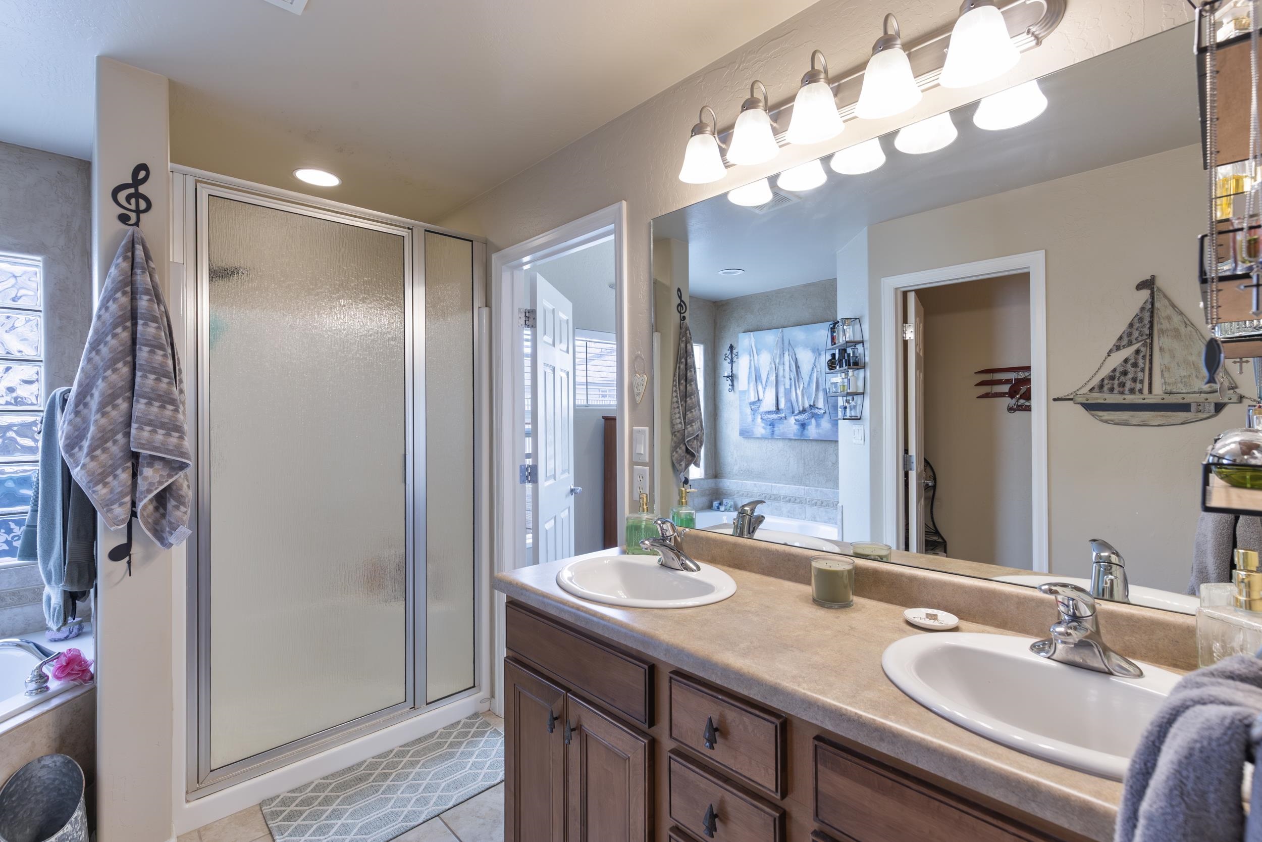 544 Hemlock Drive Fruita, CO 81521 - Photo 21 of 36 a bathroom with a granite countertop sink a shower and a mirror