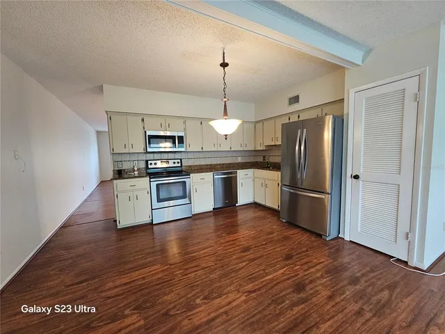 an empty room with a ceiling fan and window