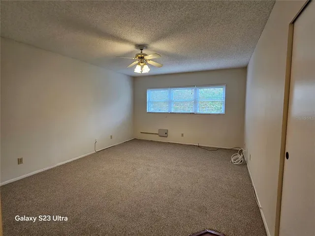 an empty room with windows and fan