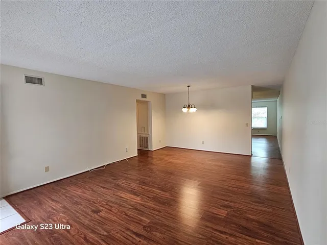 a kitchen with white cabinets appliances and wooden floor