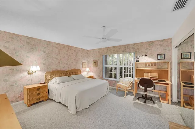 a bedroom with a bed chair and a large window