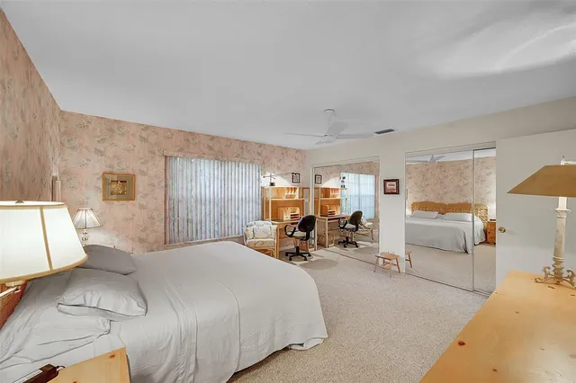 a bedroom with a bed a mirror on dresser and a chandelier