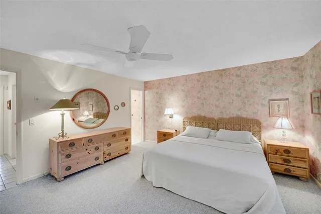 a bedroom with a bed a mirror on dresser and a chandelier