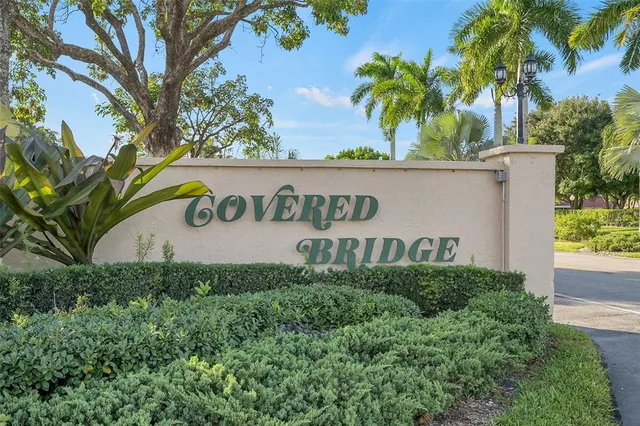 a sign of golf club on a wall under a tree