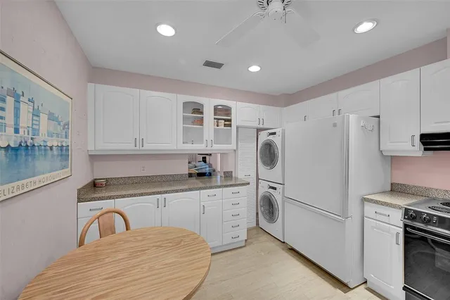a kitchen with granite countertop white cabinets and stainless steel appliances