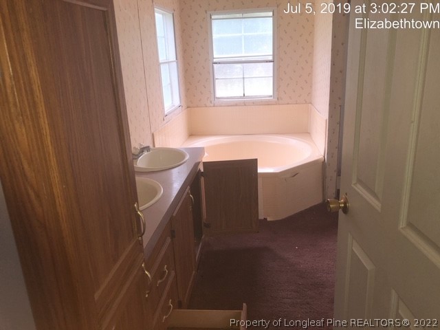 1572 Twisted Hickory Road Elizabethtown, NC 28337 - Photo 11 of 12 a bath room with a toilet and a bath tub