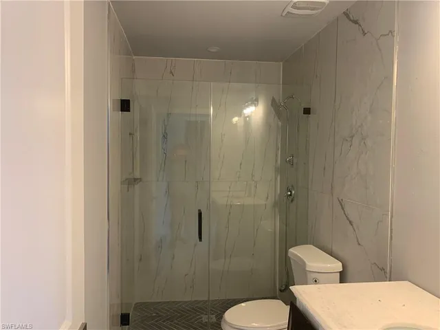 a bathroom with a toilet and a shower