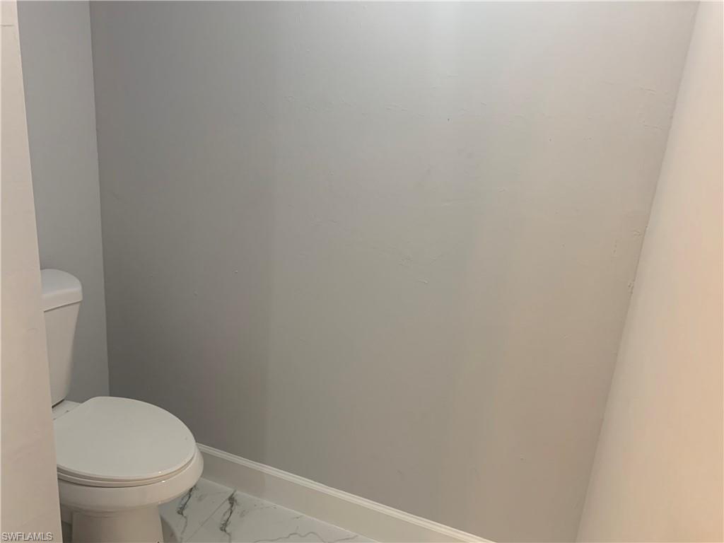 3211 43rd Street Southwest Lehigh Acres, FL 33976 - Photo 5 of 18 a white toilet sitting next to a white wall