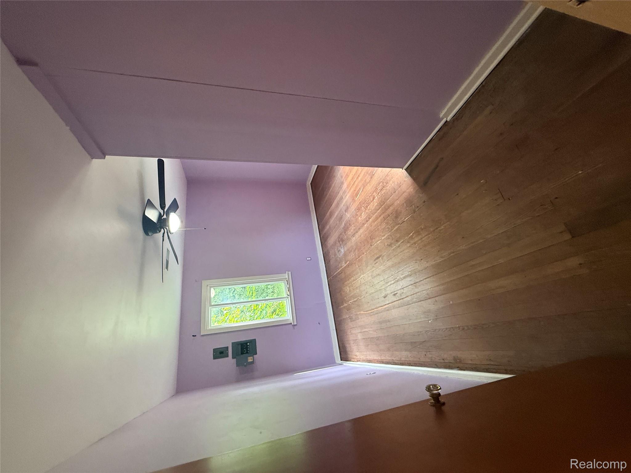 3176 East Fisher Road Bay City, MI 48706 - Photo 10 of 25 Unfurnished bedroom featuring a ceiling fan and dark wood finished floors