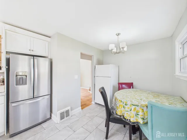 a kitchen with a refrigerator a stove a dining table and chairs