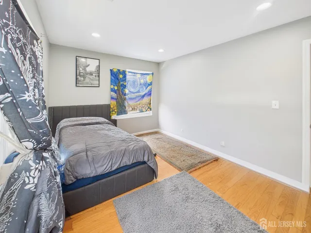 a spacious bedroom with a bed and painting on the wall