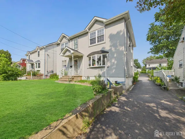 a view of a big house with a big yard and large trees