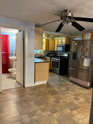 a kitchen with granite countertop a refrigerator and a stove top oven