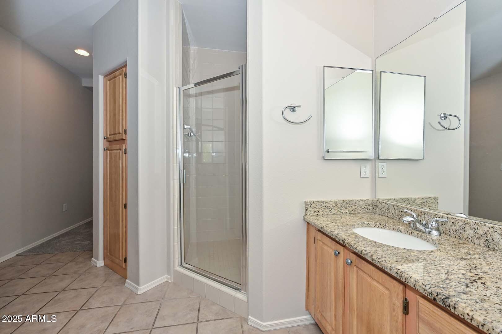 7101 West Beardsley Road, Unit 1104 Glendale, AZ 85308 - Photo 16 of 40 a bathroom with a granite countertop sink and a mirror