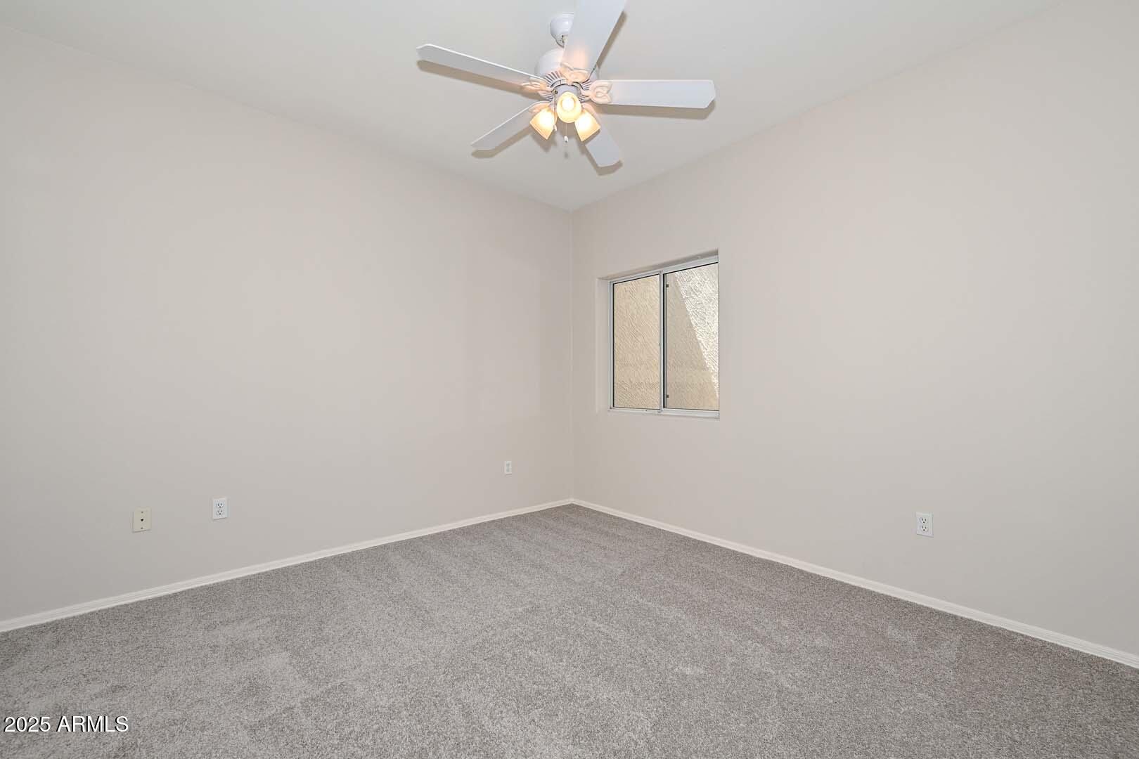 7101 West Beardsley Road, Unit 1104 Glendale, AZ 85308 - Photo 21 of 40 an empty room with a window and a fan