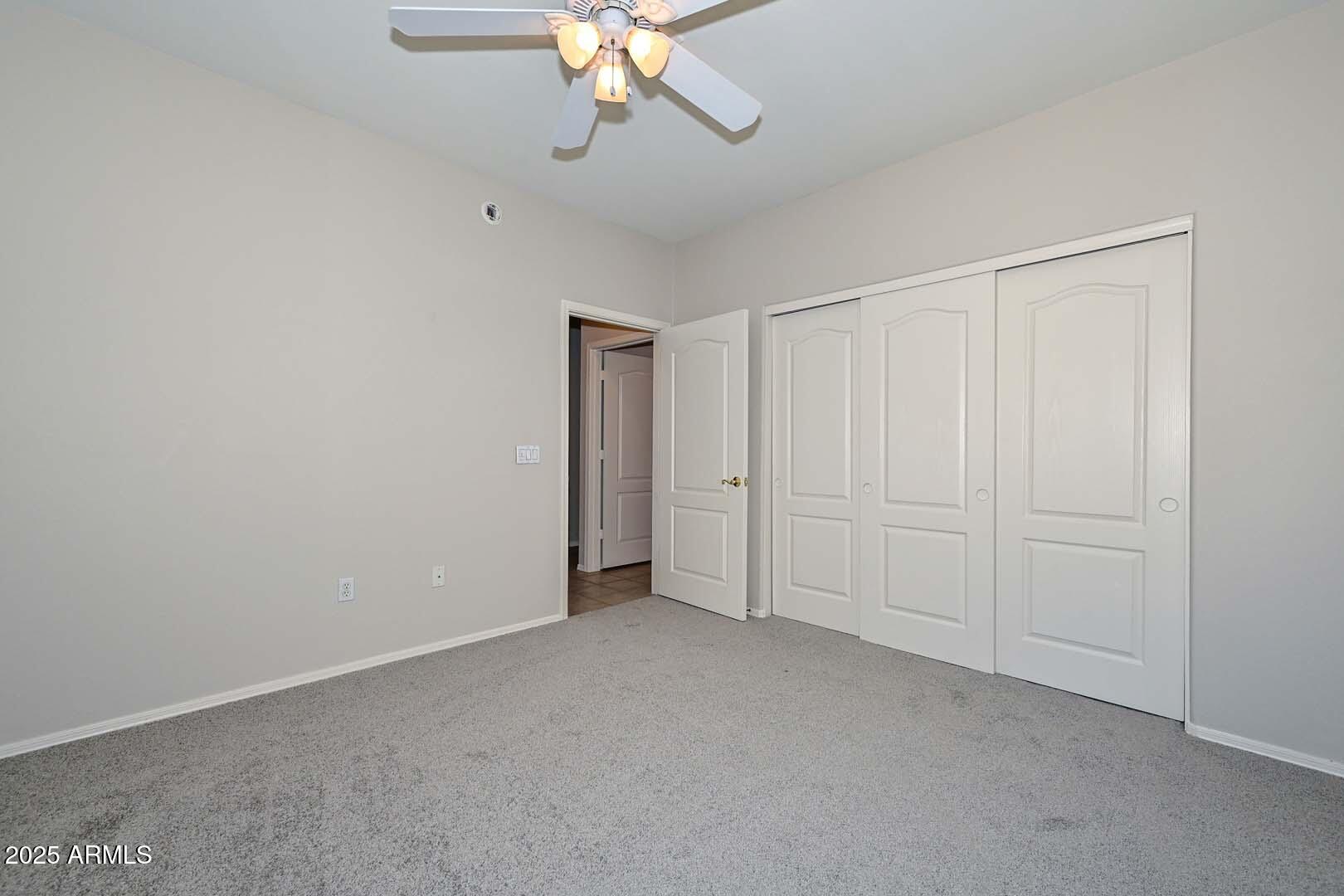 7101 West Beardsley Road, Unit 1104 Glendale, AZ 85308 - Photo 22 of 40 a view of an empty room with a chandelier fan