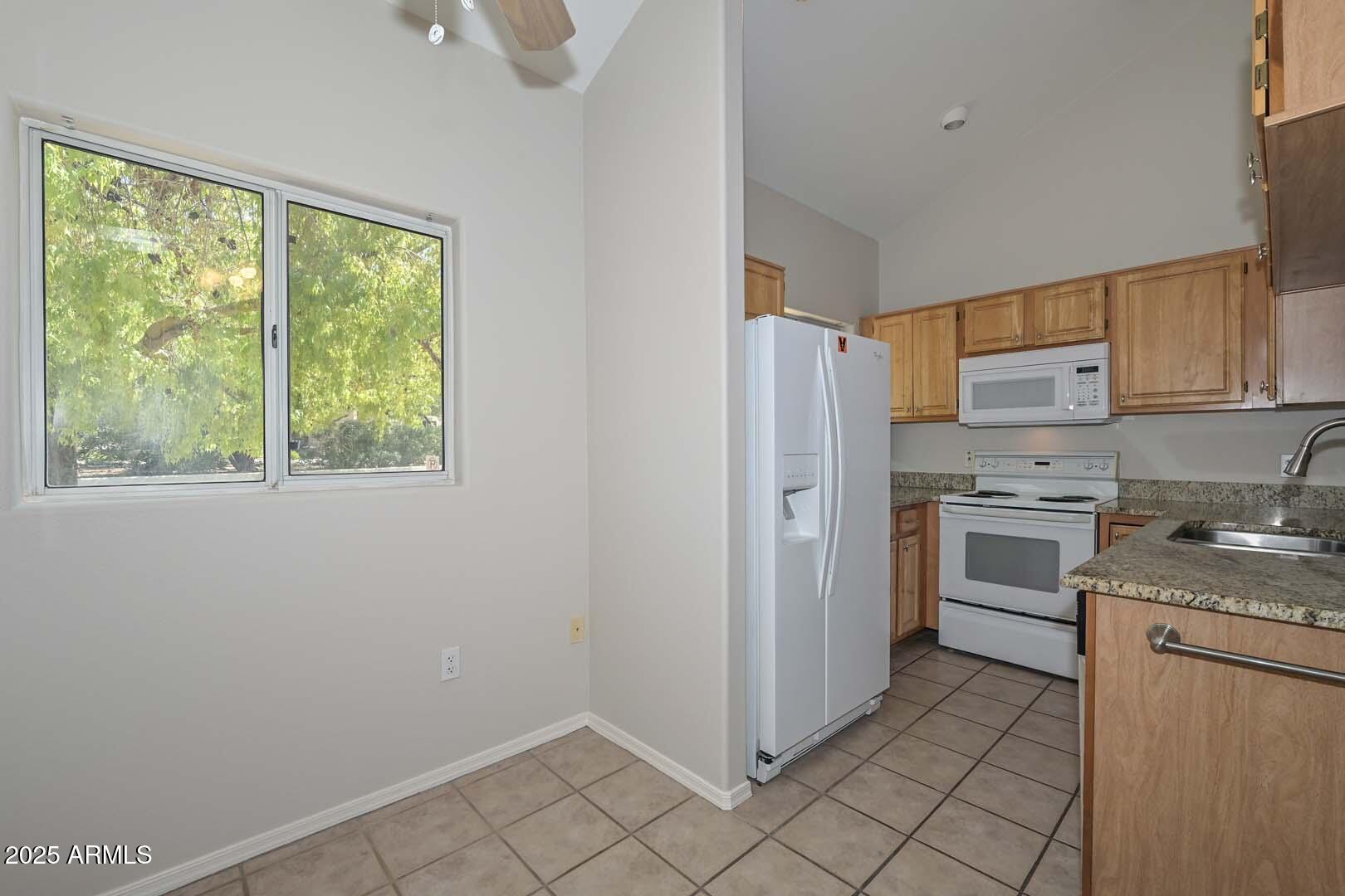 7101 West Beardsley Road, Unit 1104 Glendale, AZ 85308 - Photo 5 of 40 a kitchen with a stove a sink and a refrigerator