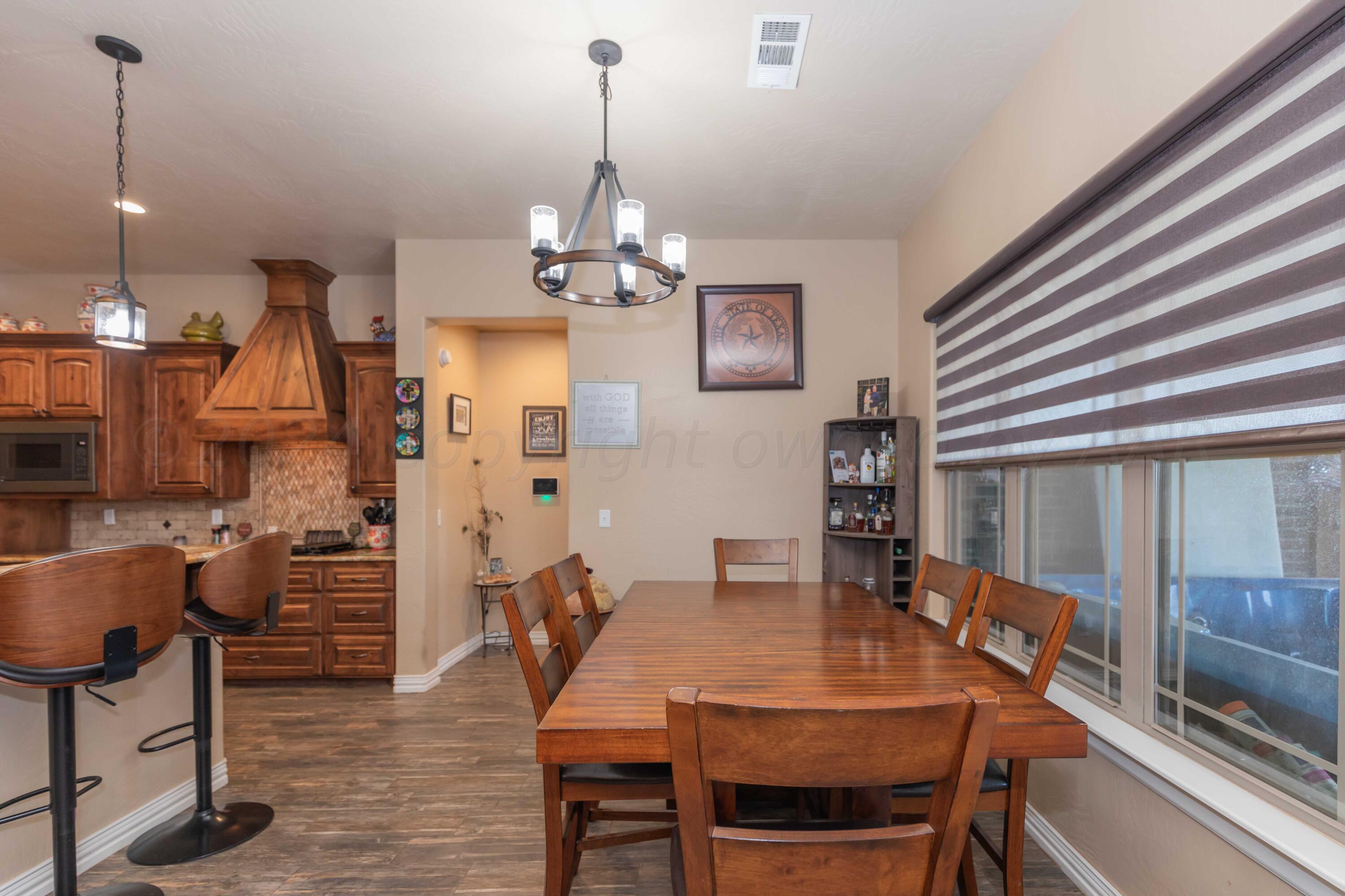 2450 Blue Springs Amarillo, TX 79124 - Photo 16 of 51 a view of a dining room and livingroom with furniture wooden floor a chandelier
