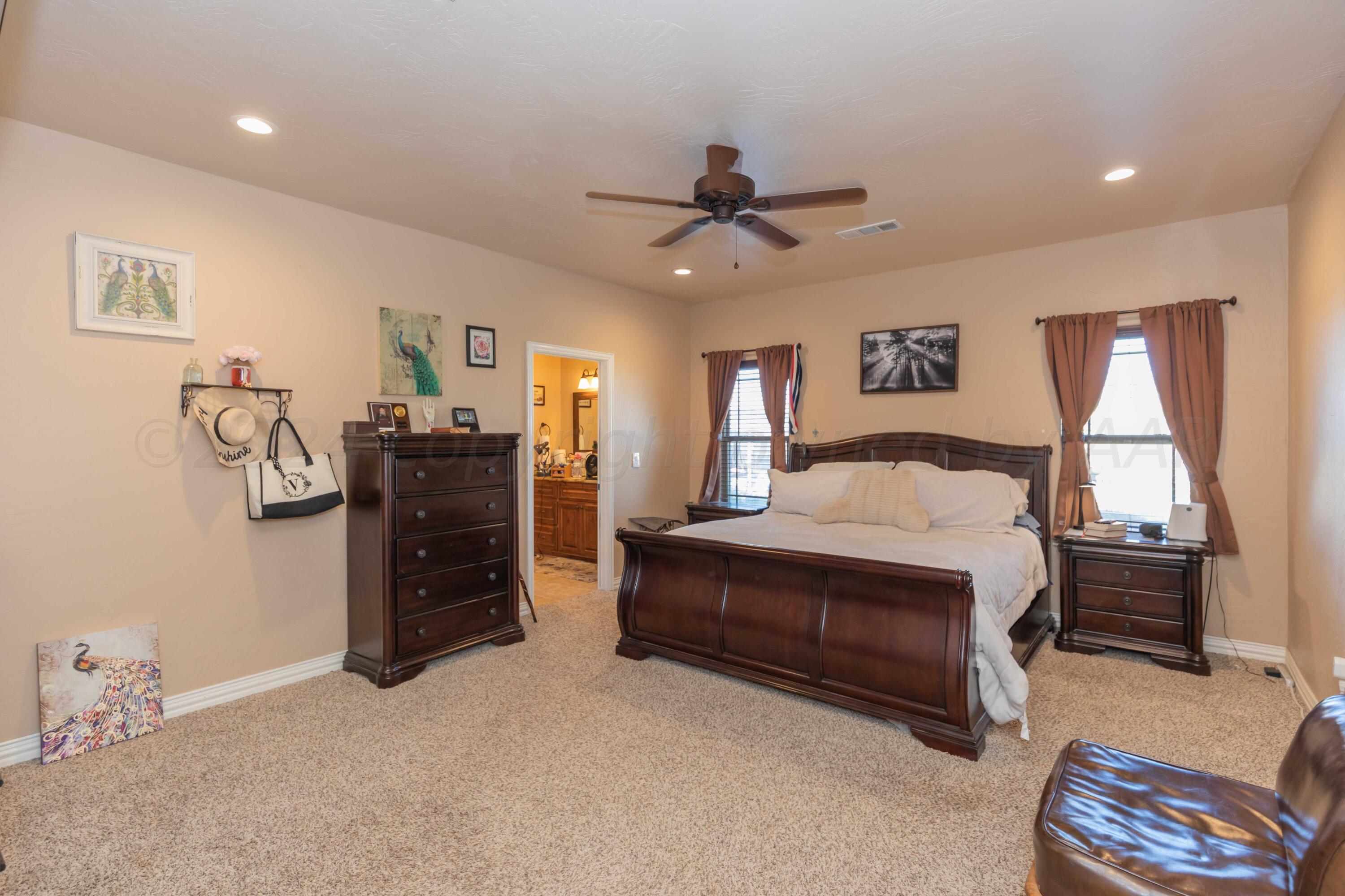 2450 Blue Springs Amarillo, TX 79124 - Photo 17 of 51 a spacious bedroom with a bed and a chandelier