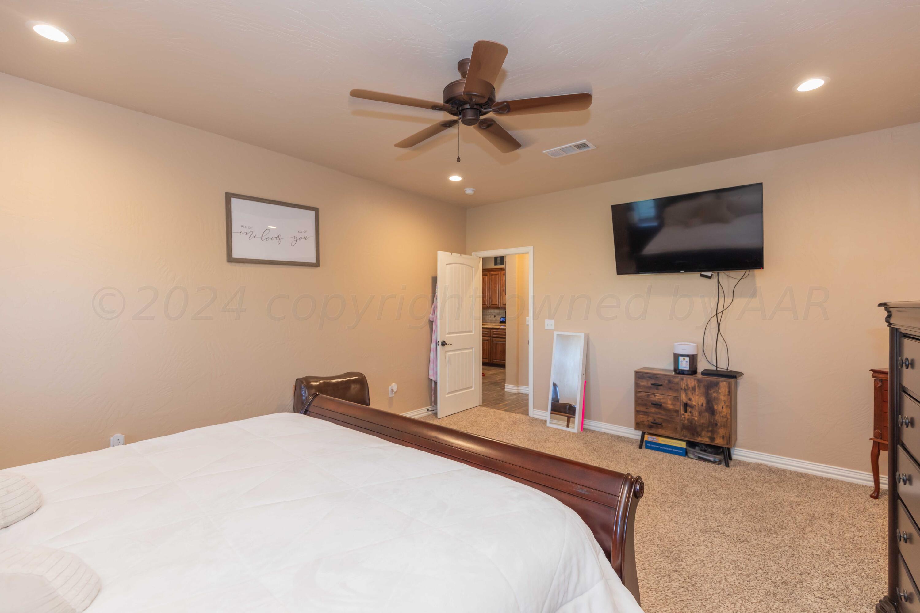 2450 Blue Springs Amarillo, TX 79124 - Photo 19 of 51 a bedroom with a bed and a flat screen tv