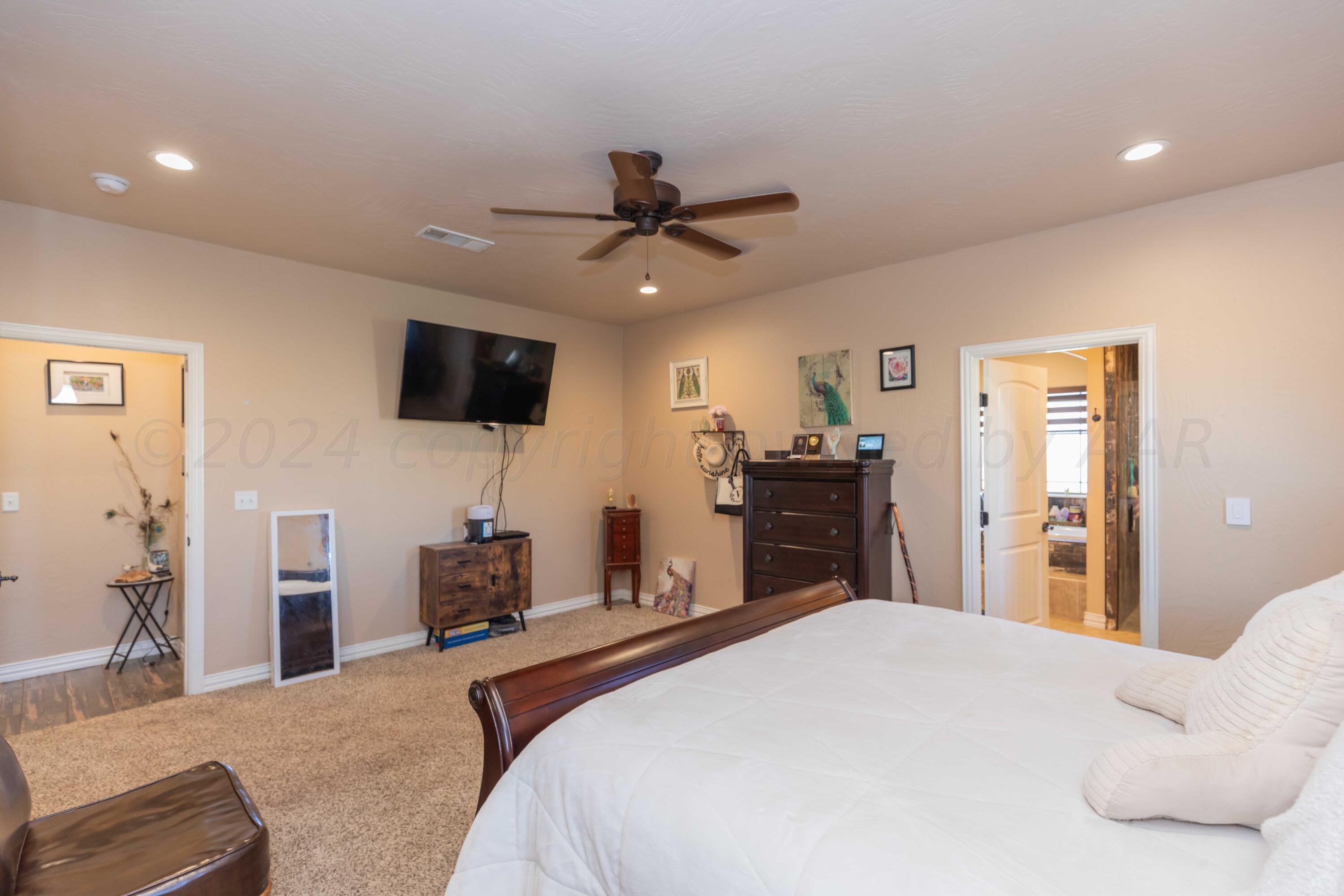 2450 Blue Springs Amarillo, TX 79124 - Photo 20 of 51 a bedroom with a bed and a flat tv screen on dresser