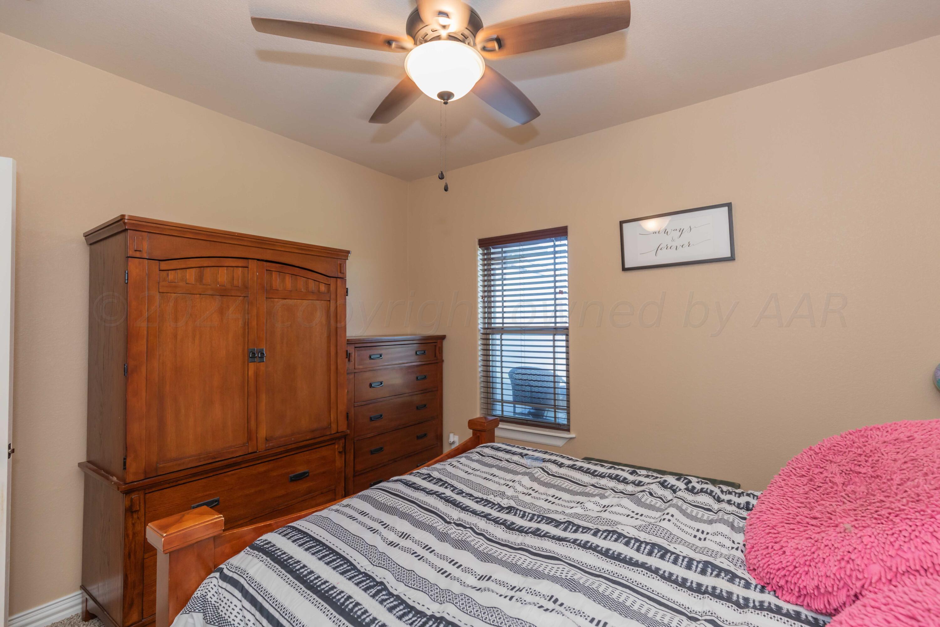 2450 Blue Springs Amarillo, TX 79124 - Photo 32 of 51 a bedroom with a bed and a chandelier