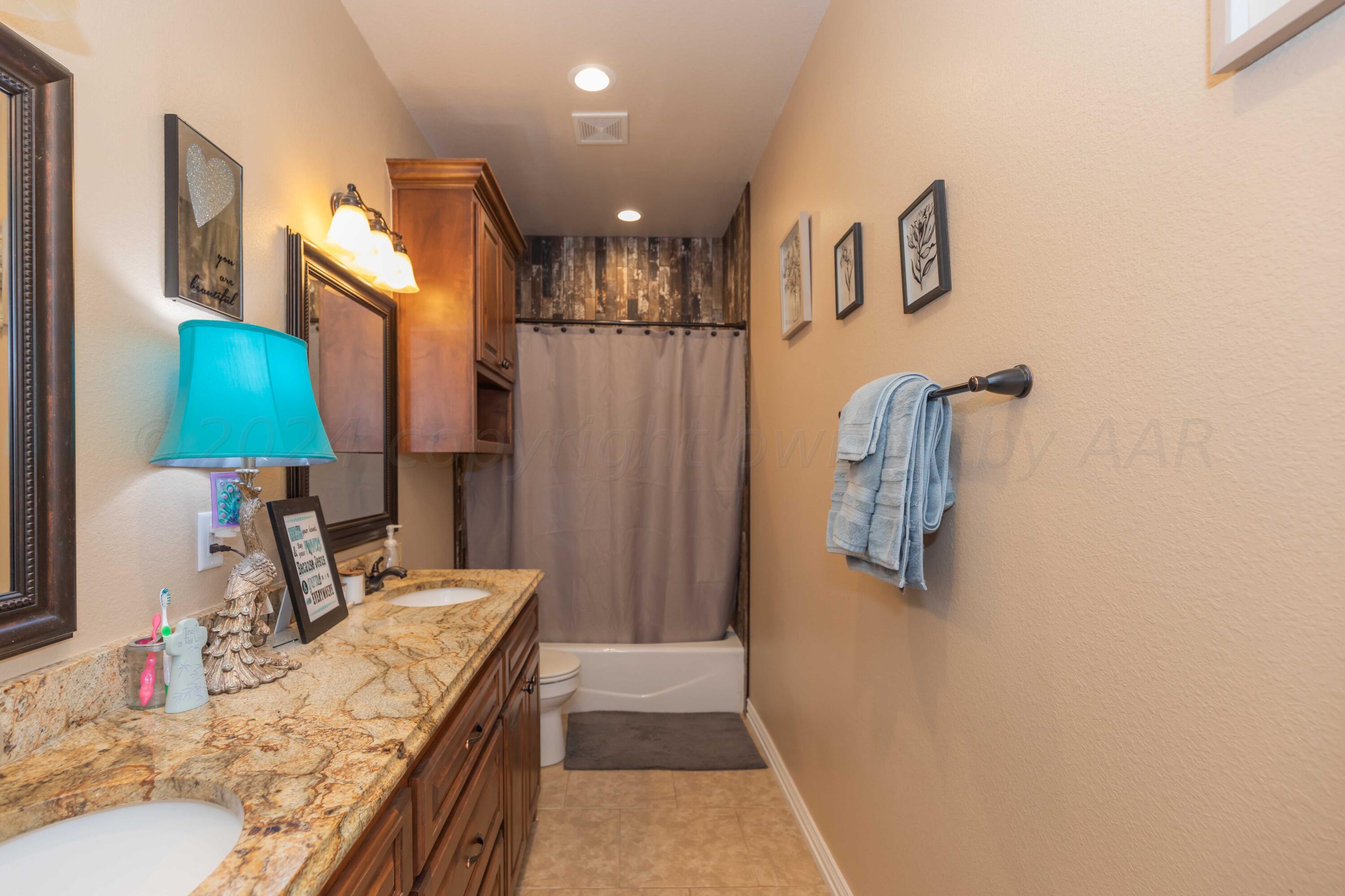 2450 Blue Springs Amarillo, TX 79124 - Photo 36 of 51 a bathroom with a granite countertop sink a mirror and shower
