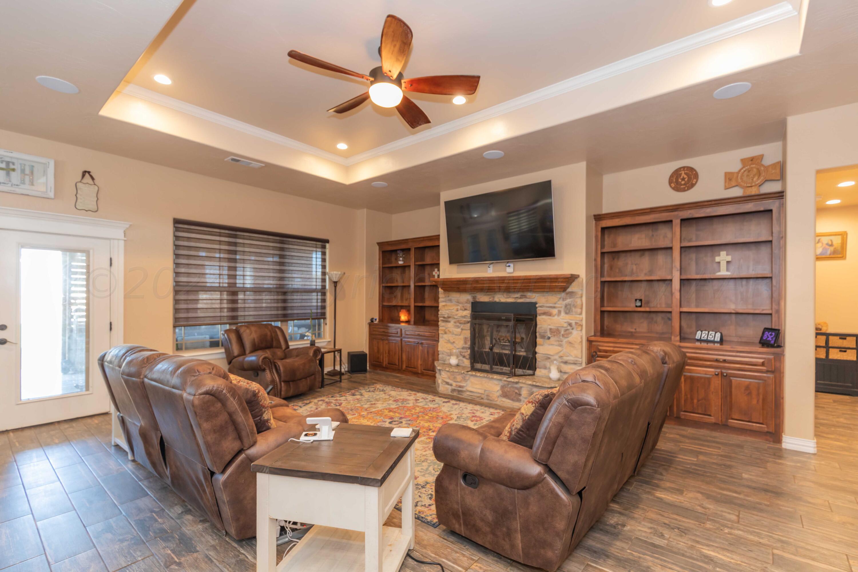 2450 Blue Springs Amarillo, TX 79124 - Photo 6 of 51 a living room with furniture a fireplace a flat screen tv and windows