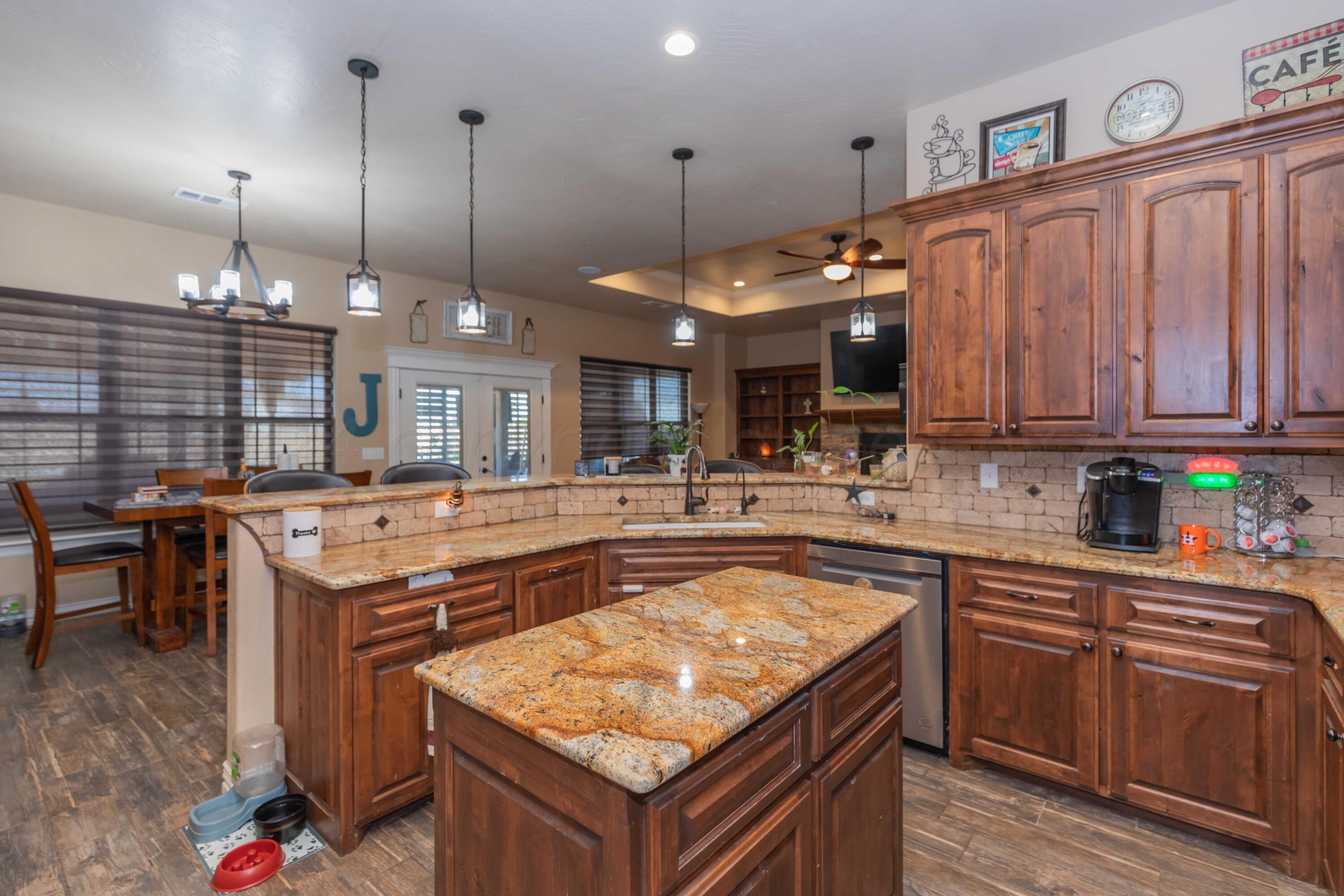 2450 Blue Springs Amarillo, TX 79124 - Photo 10 of 51 a kitchen with kitchen island granite countertop wooden cabinets and a stove