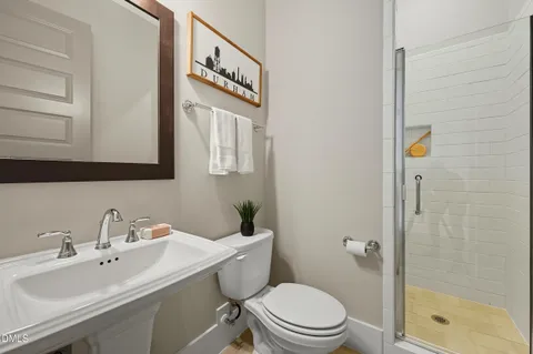 a bathroom with a sink a toilet and shower