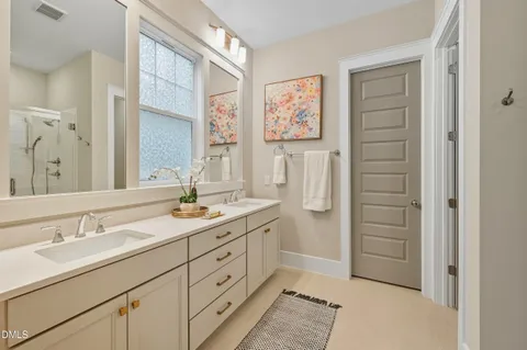 a bathroom with a double vanity sink a mirror a shower and a bathtub