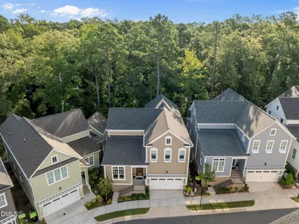a view of a white house with a yard and potted plants
