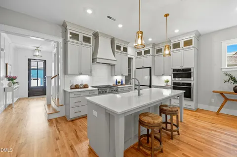a large kitchen with kitchen island a dining table chairs and a wooden floor