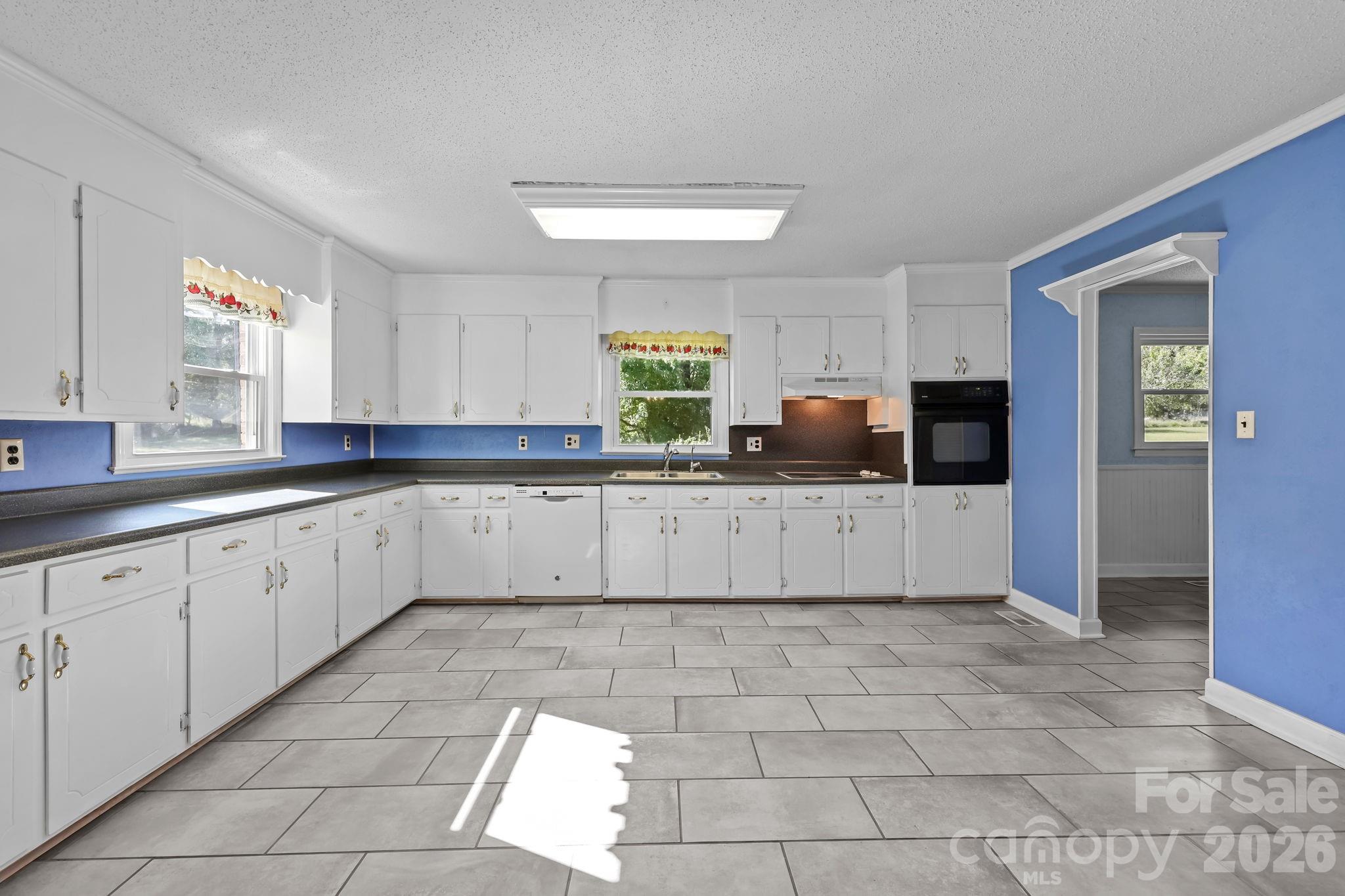 945 Alvin Hough Road Midland, NC 28107 - Photo 12 of 27 a large white kitchen with a sink and cabinets